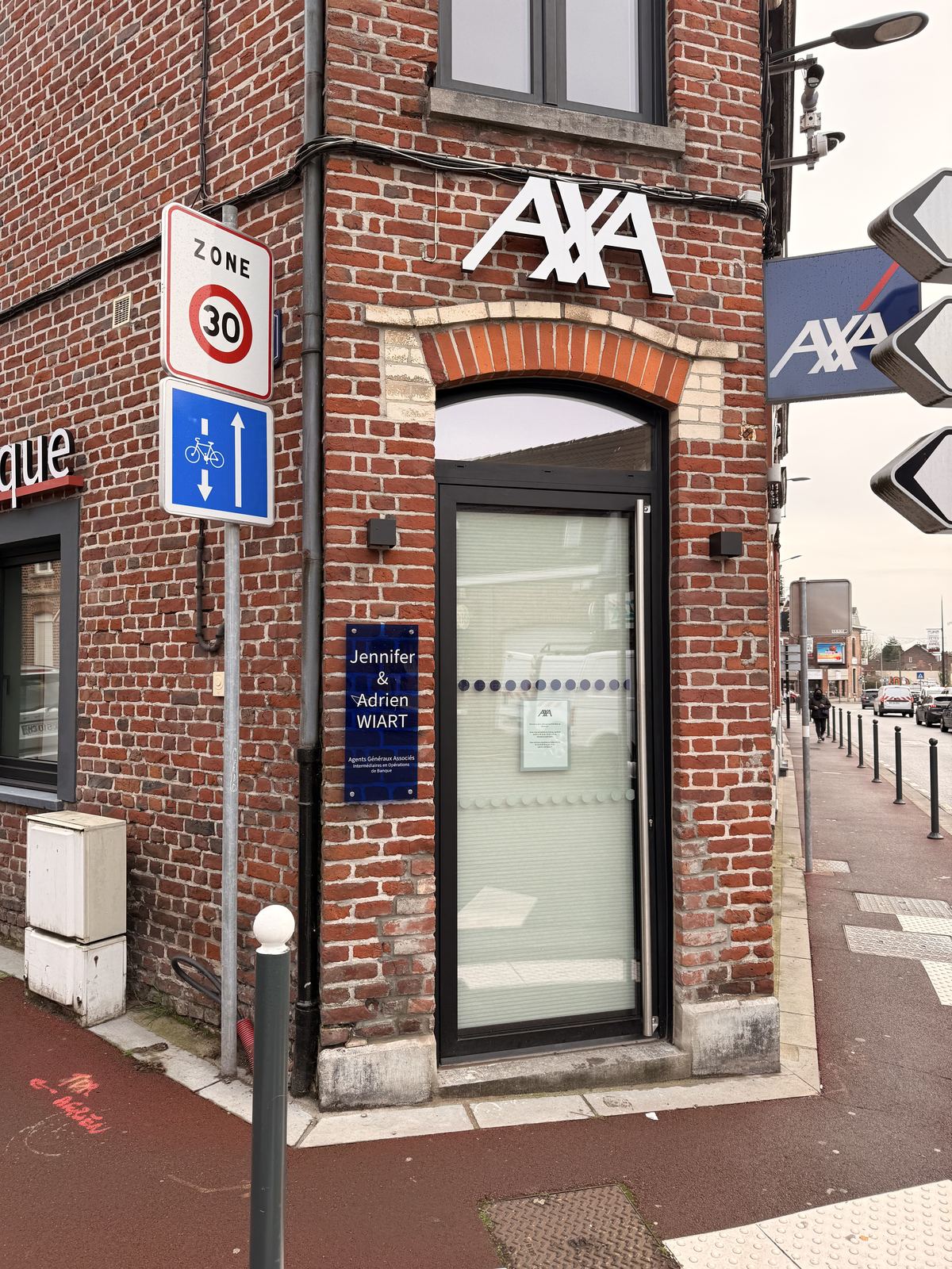 Porte vitrée aluminium anthracite d'un local professionnel en briques