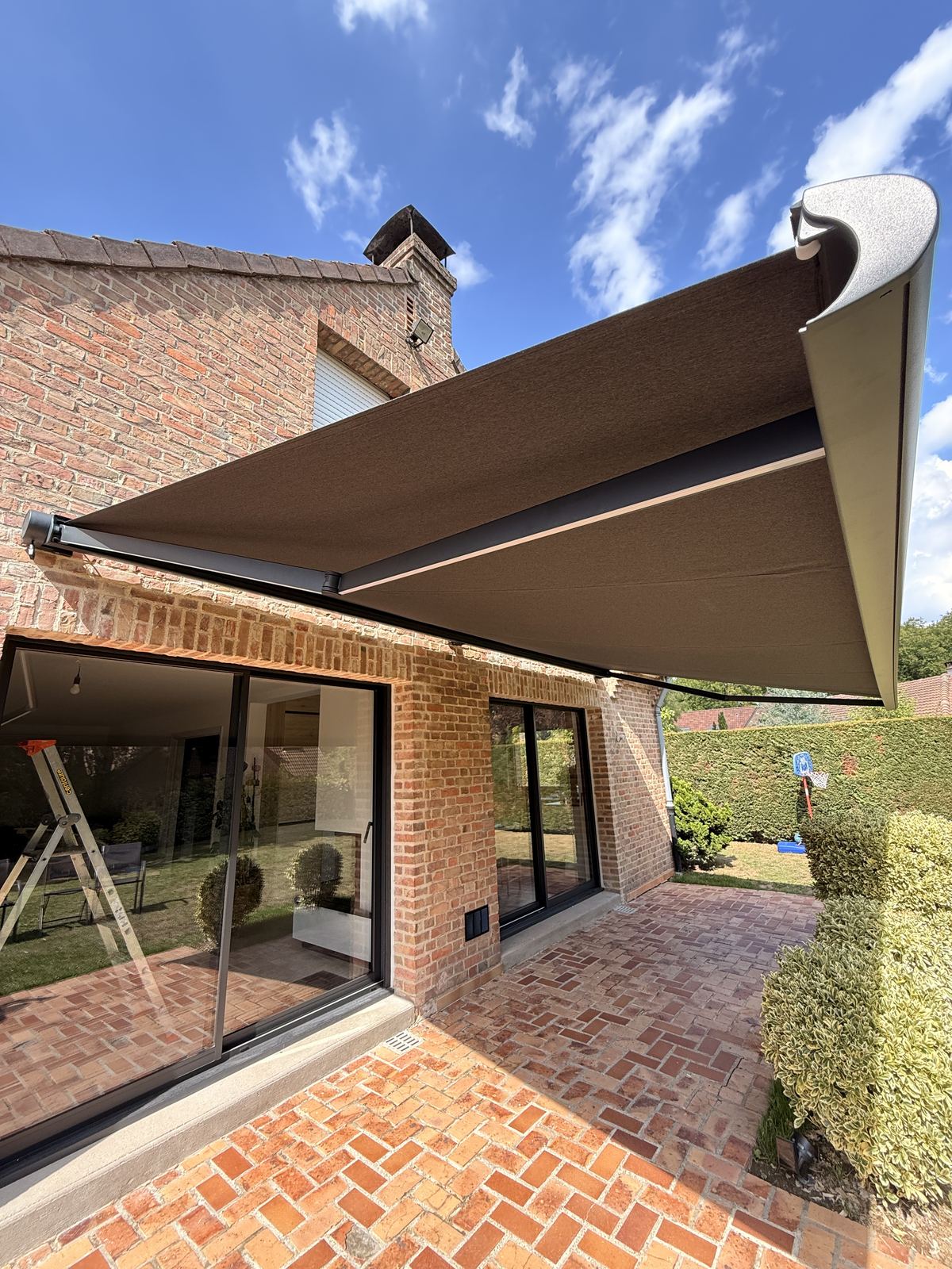 Store banne déployé au-dessus d'une terrasse, vue en contre-plongée